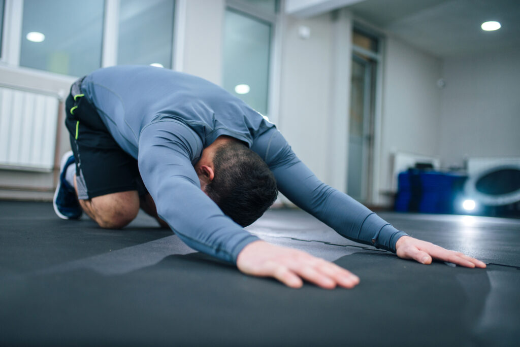 A man doing child's pose stretch.